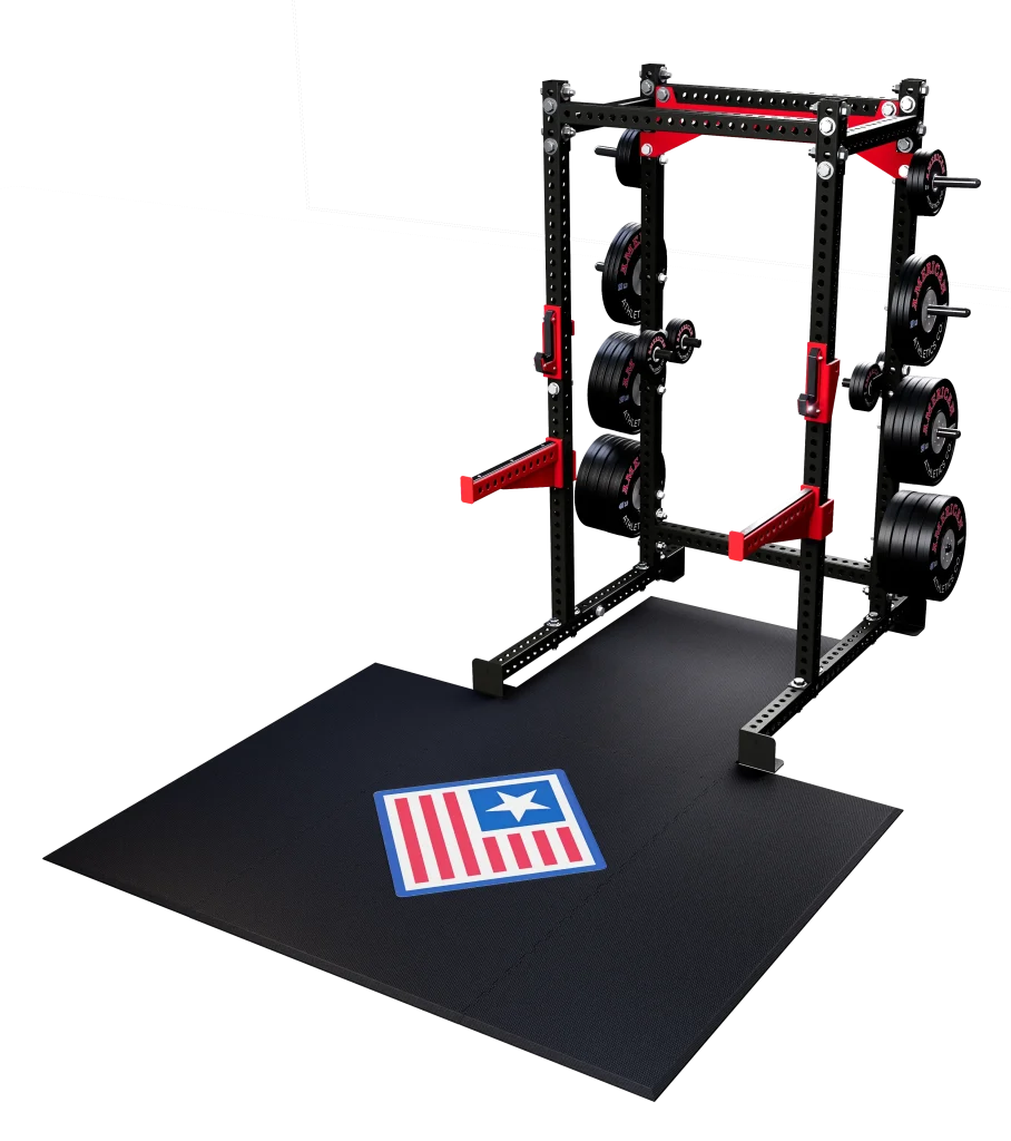 Black power rack station with red safety spotter arms, Olympic plate storage, and rubber lifting platform with flag logo.